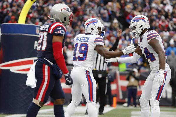 Buffalo Bills wide receiver Isaiah McKenzie (19) is congratulated by Stefon Diggs (14) after his touchdown during the first half of an NFL football game, Sunday, Dec. 26, 2021, in Foxborough, Mass. At left is New England Patriots safety Adrian Phillips (21). (AP Photo/Winslow Townson)