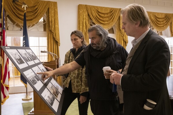 This image released by Universal Pictures shows production designer Ruth de Jong, left, with cinematographer Hoyte Van Hoytema , center, and writer-director-producer Christopher Nolan on the set of "Oppenheimer." (Melinda Sue Gordon/Universal Pictures via AP)