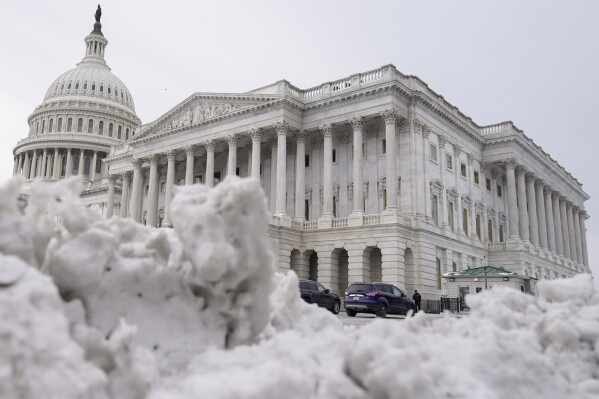 The U.S Capitol is photographed past piles of snow on Thursday, Jan. 18, 2024, in Washington. (AP Photo/Mariam Zuhaib)