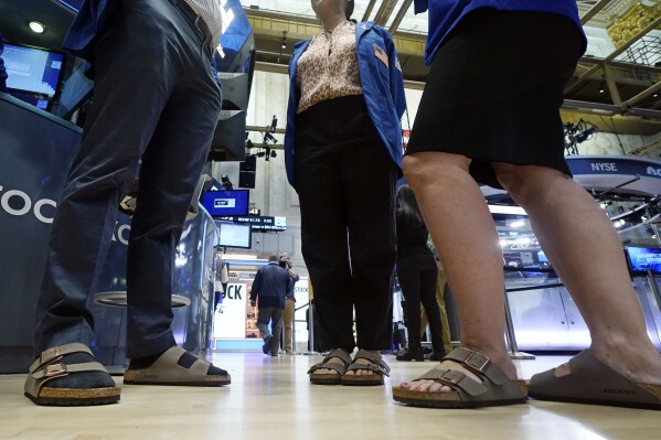 Traders on the floor of the New York Stock Exchange wear Birkenstock sandals during the company's IPO, Wednesday, Oct. 11, 2023, in New York. (AP Photo/Richard Drew)
