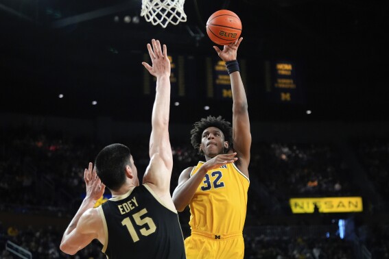 FILE - Michigan forward Tarris Reed Jr. (32) shoots against Purdue center Zach Edey (15) in the second half of an NCAA college basketball game in Ann Arbor, Mich., Sunday, Feb. 25, 2024. Former Michigan center Tarris Reed Jr. announced Wednesday, April 17, 2024, that he is transferring to UConn. (AP Photo/Paul Sancya, File)