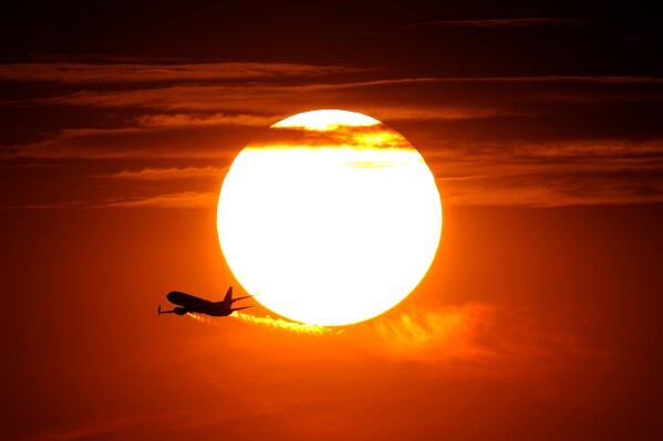 A jet takes flight from Sky Harbor International Airport as the sun sets, Wednesday, July 12, 2023 in Phoenix. (AP Photo/Matt York)