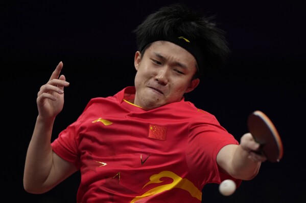 FILE - China's Wang Chuqin returns a ball from Hong Kong's Wong Chun Ting during the Table Tennis Men's Singles semi-final match for the 19th Asian Games in Hangzhou, Monday, Oct. 2, 2023. No. 1 in the men's singles ranking, Wang was an alternate for the Chinese team at the Tokyo Games. (AP Photo/Ng Han Guan, File)