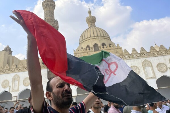 A protester waves a Palestinian flag reading ''Al-Aqsa flood'', after Friday prayers at Azhar mosque, the Sunni Muslim world's premier Islamic institution, in Cairo, Egypt, Friday, Oct. 13, 2023. (AP Photo/Amr Nabil)