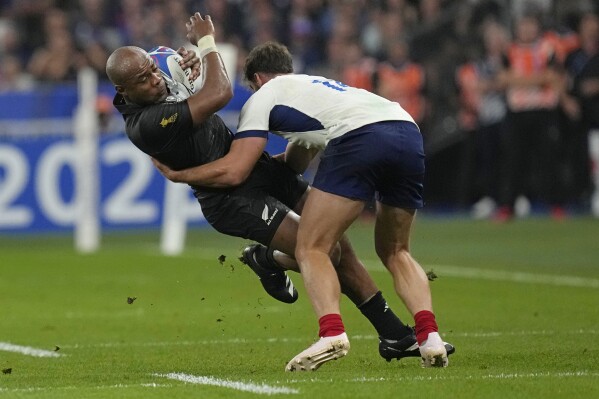 New Zealand's Mark Telea, left, is tackled by France's Damian Penaud during the Rugby World Cup Pool A match between France and New Zealand at the Stade de France in Saint-Denis, north of Paris, Friday, Sept. 8, 2023. (AP Photo/Thibault Camus)