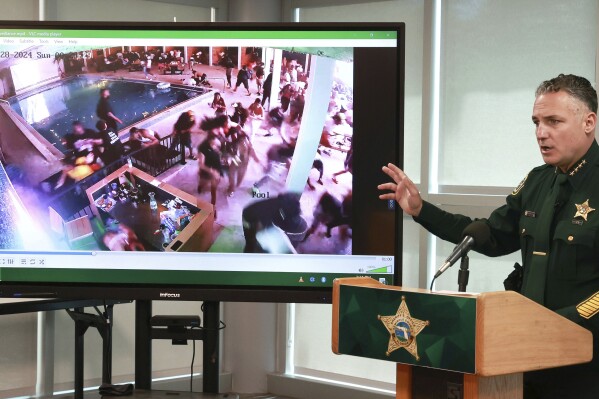 During a press conference in Sanford, Fla., Monday, April 29, 2024, Seminole County Sheriff Dennis Lemma shows a surveillance video taken early Sunday of patrons fleeing the Cabana Live nightclub in Sanford, during shots fired by gunmen. Multiple patrons in the club, including NFL Houston Texans wide receiver Tank Dell, were wounded by the gunfire. (Joe Burbank/Orlando Sentinel via AP)
