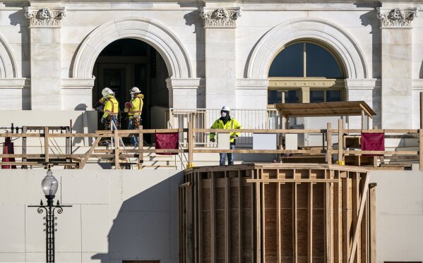 With Inauguration Day two months away, construction crews work on the platforms where the president-elect will take the oath of office, at the Capitol in Washington, Nov. 18, 2020. (AP Photo/J. Scott Applewhite)