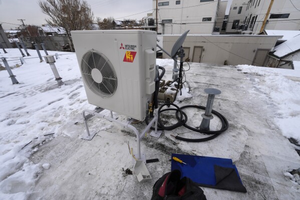 FILE - A condenser sits on the roof during the installation of a heat pump on Jan. 20, 2023, in Denver. A bipartisan coalition of about 25 governors and the Biden administration are set to announce a pledge Thursday, Sept. 21, 2023, to quadruple the number of heat pumps in U.S. homes by 2030. (AP Photo/David Zalubowski, File)