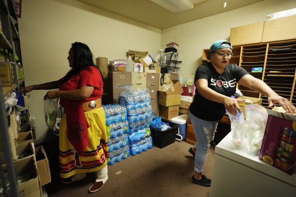 Grassroots advocates Reva Stewart, left, and Raquel Moody, right, pack up individual hygiene kits for clients at Drumbeat Indian Arts, Monday, July 31, 2023, in Phoenix. The women are trying to help find lost Native Americans who were left without a place to stay after the phony treatment centers in the Phoenix area abruptly shut down when Arizona cut off their Medicaid money amid investigations into widespread fraudulent billing. (AP Photo/Ross D. Franklin)