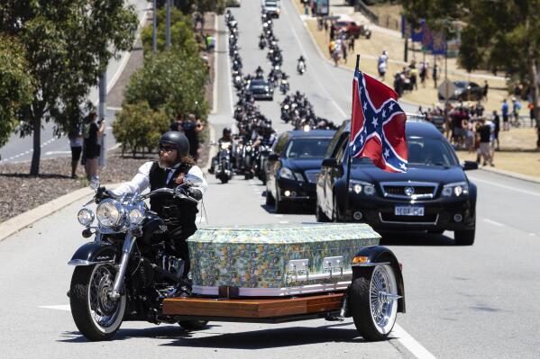 A motorcade follows the coffin of Rebels biker Nick Martin into Pinnaroo Cemetery in Perth, Australia, on Wednesday, Dec. 23, 2020. The former Rebels president was gunned down earlier in the month at the Perth Motorplex. Martin’s murder left police a trove of evidence that led them to the culprit. But they wanted more. The coronavirus pandemic provided it in the form of an electronic dragnet: QR code check-in data from contact tracing apps of 2,439 fans who attended the December 2020 race. (Richard Wainwright/AAP via AP)
