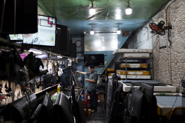 A technician repairs a TV in a shop in Nhat Tao market, the largest informal recycling market in Ho Chi Minh City, Vietnam, Sunday, Jan. 28, 2024. The world is producing more electronic waste than ever. And it's growing faster than formal efforts to recycle it. (AP Photo/Jae C. Hong)