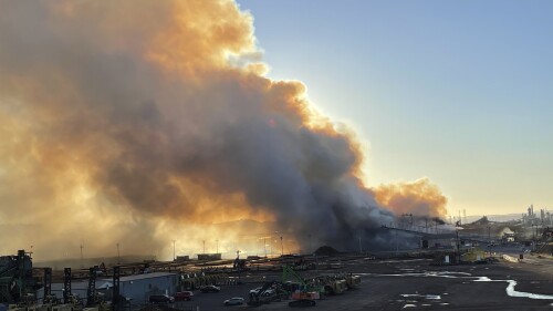 A large smoke plume from an industrial fire fueled by wood chip piles at an paper plant in Longview, Wash., is seen at sunset, Tuesday, July 18, 2023. The fire at Nippon Dynawave Packaging is worsening air quality in northwest Oregon and southwest Washington and officials warned those in the immediate area to stay inside and keep doors and windows closed. No injuries have been reported and officials are investigating. (Matt Esnayra/Longview Daily News via AP)
