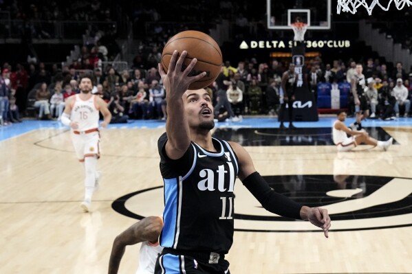 Atlanta Hawks guard Trae Young (11) scores against the San Antonio Spurs during the first half of an NBA basketball game Monday, Jan. 15, 2024, in Atlanta. (AP Photo/John Bazemore)