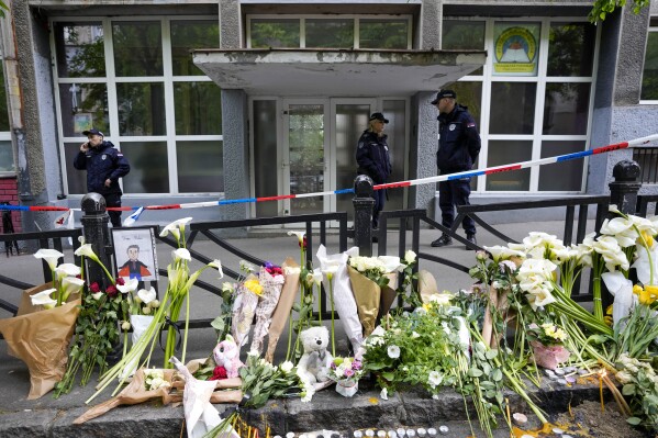 FILE - Police officers guard the Vladimir Ribnikar school in Belgrade, Serbia, on May 4, 2023 after a 13-year-old opened fire killing fellow students and a guard. A trial started Monday Jan. 29, 2024 in Serbia for the parents of a teenager who is accused of killing 10 people and injuring six in a mass shooting at his school last May that left the Balkan nation in shock. (AP Photo/Darko Vojinovic, File)