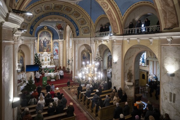 Members of Ukraine's ethnic Hungarian minority attend a mass at a Catholic church in Uzhhorod, Sunday, Jan. 28, 2024. Ukraine amended its laws to comply with EU membership requirements, and restored many of the language rights for minorities demanded by Budapest but Hungary's government has indicated it is not fully satisfied — a potentially explosive sticking point as EU leaders meet Thursday, Feb. 1, 2024 to try and break Orban's veto of a major aid package earmarked for Kyiv. (AP Photo/Denes Erdos)