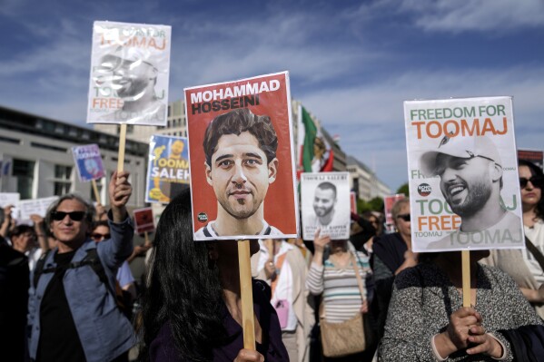 FILE - Protesters attend a rally against a death sentence given to a popular rapper in Iran and to support to the women of Iran, in Berlin, Germany, April 28, 2024. Lawmakers are introducing legislation targeting Iranian officials involved in the prosecution and planned execution of rapper Toomaj Salehi, who rose to fame with lyrics about the 2022 death of Mahsa Amini and for criticism of the Islamic Republic. (AP Photo/Ebrahim Noroozi, File)