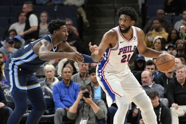 Philadelphia 76ers center Joel Embiid (21) handles the ball against Memphis Grizzlies forward Jaren Jackson Jr. (13) in the first half of an NBA basketball game Wednesday, Nov. 20, 2024, in Memphis, Tenn. (AP Photo/Brandon Dill)