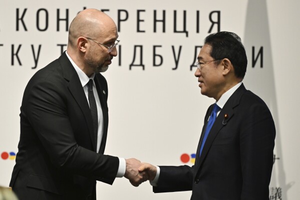 Ukraine's Prime Minister Denys Shmyhal shakes hands with Japanese Prime Minister Fumio Kishida during the Japan-Ukraine Conference for Promotion of Economic Growth and Reconstruction at Keidanren Kaikan building in Tokyo, Monday, Feb. 19, 2024. (Kazuhiro Nogi/Pool Photo via AP)