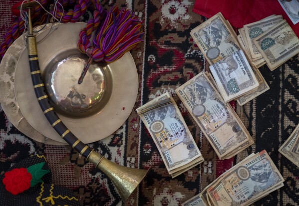 Members of Shrijanshil Mahila Sanstha, or the Self-Reliant Women’s Group, distribute their earnings after playing at a wedding in Kathmandu, Nepal, Thursday, March 7, 2024. (AP Photo/Niranjan Shrestha)