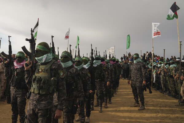 Hamas fighters deploy ahead of handing over four bodies to the Red Cross in Khan Younis, southern Gaza Strip, Thursday, Feb. 20, 2025. Israel has identified three of the bodies as hostages and said the other was of an unknown person. (AP Photo/Abdel Kareem Hana)