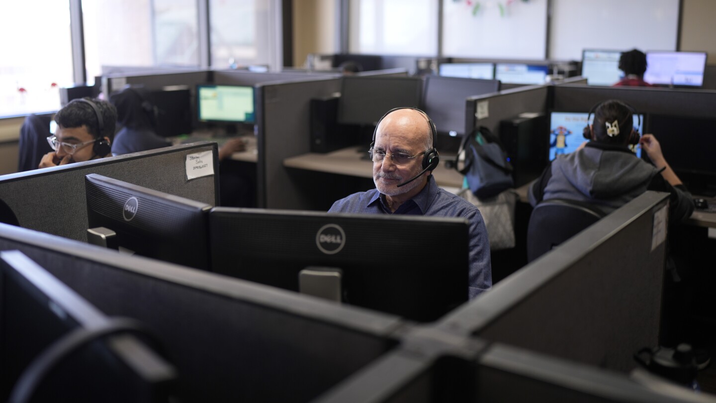 Customer Experience Representatives Stanley Solis, center, and other representatives take calls at an Alorica center, Monday, Aug. 19, 2024, in San An