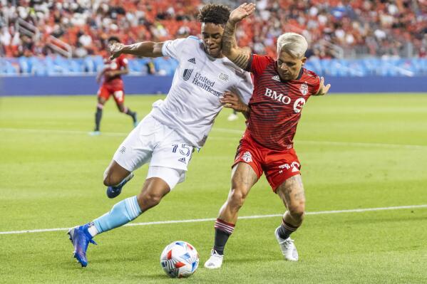 Toronto FC's Yeferson Soteldo, right, works against New England Revolution's Brandon Bye for the ball during the first half of an MLS soccer match Saturday, Aug. 14, 2021, in Toronto. (Mark Blinch/The Canadian Press via AP)