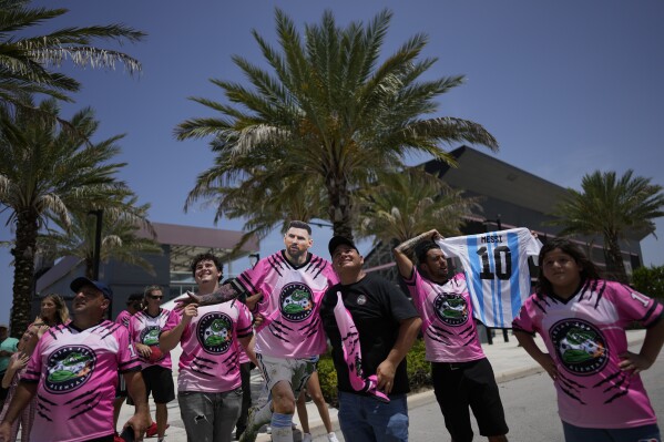 A group of South Florida fans waits outside DRV PNK Stadium, home of Inter Miami MLS soccer club, in hopes of catching a glimpse of Argentine soccer superstar Lionel Messi, Tuesday, July 11, 2023, in Fort Lauderdale, Fla. Inter Miami has announced plans to present Messi along with other new players at an event on July 16. (AP Photo/Rebecca Blackwell)