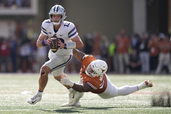FILE - Kansas State quarterback Will Howard (18) is pressured by Texas defensive lineman Byron Murphy II (90) during overtime in an NCAA college football game in Austin, Texas, Saturday, Nov. 4, 2023. Texas coach Steve Sarkisian calls defensive tackles T’Vondre Sweat, an Outland Trophy finalist, and Byron Murphy II the best interior linemen tandem in the country and the anchor for a defense that leads the nation in third down efficiency and red zone defense. (AP Photo/Eric Gay, File)