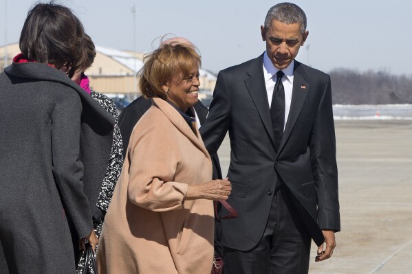 FILE - Marian Robinson, mother of first lady Michelle Obama, center left, smiles as she boards Air Force One with President Barack Obama en route to the commemoration of the 50th anniversary of "Bloody Sunday," a landmark event of the civil rights movement, from Andrews Air Force Base, Md., March 7, 2015. Robinson, who moved with the first family to the White House when son-in-law Barack Obama was elected president, has died, according to an announcement by Michelle Obama and other family members Friday, May 31, 2024. (AP Photo/Jacquelyn Martin, File)
