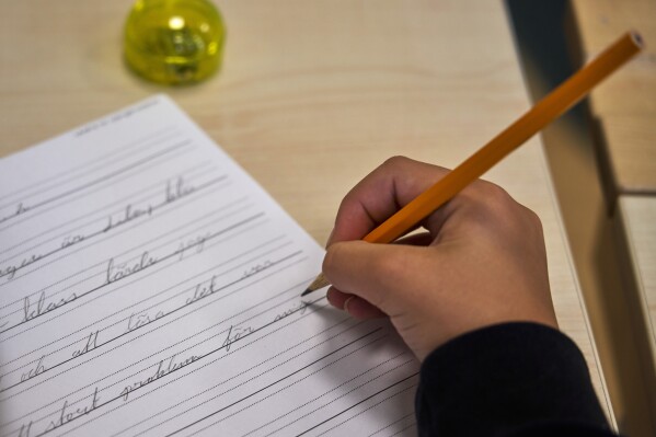 A child practices handwriting at the Djurgardsskolan elementary school in Stockholm, Sweden, Thursday, Aug. 31, 2023. As children across Sweden have recently flocked back to school after the summer vacation, many of their teachers are putting a new emphasis on printed books, quiet reading hours, and practicing handwriting as the country's yearslong focus on the digitalization of classrooms has come under scrutiny. (AP Photo/David Keyton)