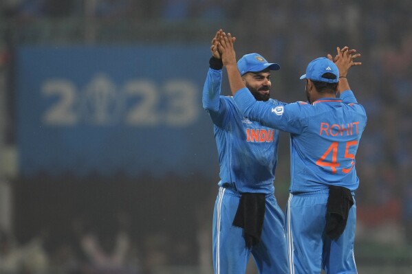 India's Virat Kohli celebrates with captain Rohit Sharma after India won by 100 runs against England during the ICC Men's Cricket World Cup match in Lucknow, India, Sunday, Oct. 29, 2023. (AP Photo/Manish Swarup)