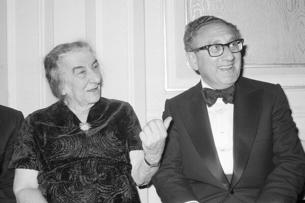 FILE - Former U.S. Secretary of State Henry Kissinger and former Israeli Prime Minister Golda Meir chat after an American Jewish Congress Dinner, Sunday night Nov. 4, 1977, in New York. Henry Kissinger's legacy in the Mideast is the pursuit of what's possible, not necessarily peace, in one of the world's most intractable conflicts. The former U.S. secretary of state, who died this week at age 100, did just that after Egypt and Syria pulled of a surprise invasion of Israel 50 years ago. (AP Photo/Ira Schwarz, File)