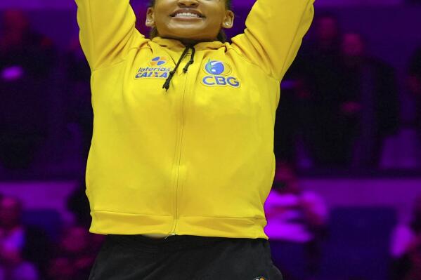 Gold medalist Rebeca Andrade of Brazil celebrates during a medal ceremony for the Women's All-Around Final during the Artistic Gymnastics World Championships at M&S Bank Arena in Liverpool, England, Thursday, Nov. 3, 2022. (AP Photo/Jon Super)