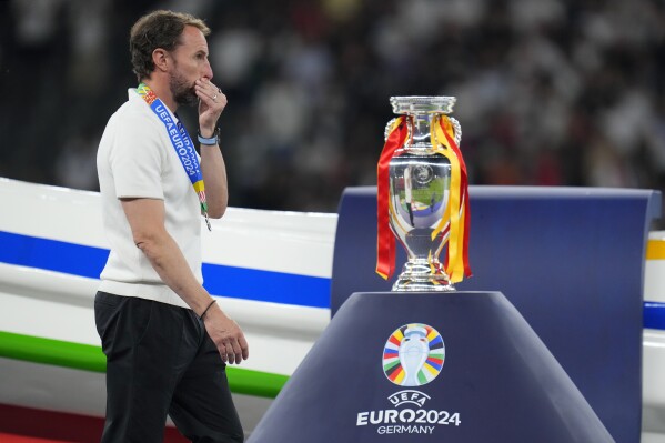 FILE - England's manager Gareth Southgate walks past the trophy at the end of the final match between Spain and England at the Euro 2024 soccer tournament in Berlin, Germany, Sunday, July 14, 2024. Spain won 2-1. Gareth Southgate announces he will step down as England manager (AP Photo/Manu Fernandez, File)
