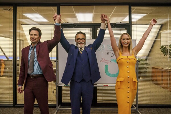 This image released by Netflix shows Chris Evans as Brenner, left, Andy Garcia as Neel, center, and Emily Blunt as Liza in a scene from "Pain Hustlers." (Brian Douglas/Netflix via AP)