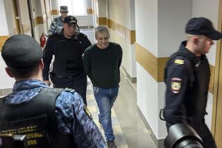 Semiel Vedel, center, is escorted into a courtroom in Moscow, Russia, Monday, April 24, 2023. A court in Russia has convicted a former police officer of publicly spreading false information about the country's military for criticizing the war in Ukraine to his friends. The ex-officer Semiel Vedel was sentenced Monday to seven years in prison under a law the Kremlin has actively used to stifle dissent. (AP Photo)