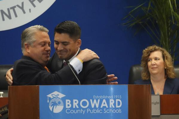 New Broward County School Board member Ryan Reiter, right, is congratulated by Fla., State Rep. Chip LaMarca, left, at school district headquarters in Fort Lauderdale, Fla., Tuesday, Aug. 30, 2022. A grand jury report led to the suspension of four of the board members by Gov. Ron DeSantis who appointed the replacements. (Joe Cavaretta