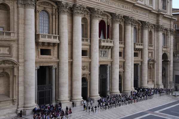 People gather under Pope's balcony in St. Peter's Square where 133 cardinals are gathering on the second day of the conclave to elect successor of late Pope Francis, at the Vatican, Thursday, May 8, 2025. (AP Photo/Gregorio Borgia)