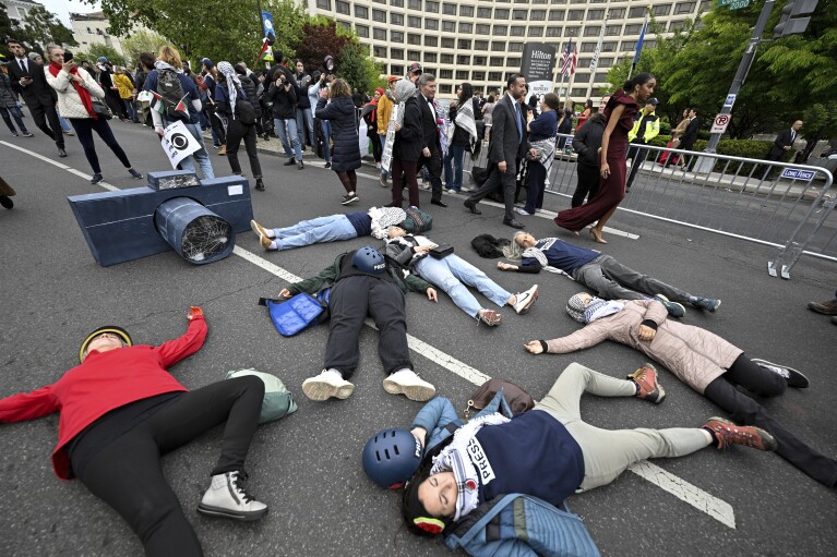 Demonstranci leżą na ulicy podczas propalestyńskiej demonstracji przeciwko wojnie między Izraelem a Hamasem przed kolacją Stowarzyszenia Korespondentów Białego Domu w hotelu Washington Hilton, sobota, 27 kwietnia 2024 r. w Waszyngtonie.  (AP Photo/Terrence Williams)