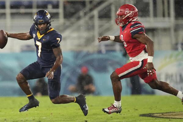 Toledo quarterback Dequan Finn (7) runs away from Liberty linebacker Jerome Jolly Jr. (0) during the first half of the Boca Raton Bowl NCAA college football game Tuesday, Dec. 20, 2022, in Boca Raton, Fla. (AP Photo/Jim Rassol)