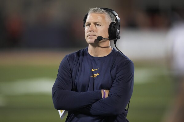 FILE - Toledo coach Jason Candle walks the sideline during the second half of the team's NCAA college football game against Illinois on Saturday, Sept. 2, 2023, in Champaign, Ill. No. 23 Toledo, ranked in the AP Top 25 poll for the first time since 2015, will visit Central Michigan on Friday, Nov. 24, with a chance to accomplish some rarities for a Mid-American Conference team. With a win over the Chippewas in the regular-season finale, the Rockets (10-1, 7-0 MAC) can become the first school to go 8-0 in the MAC since 2016 and keep themselves in the conversation to earn a possible berth in the New Year's Six bowl lineup. (AP Photo/Charles Rex Arbogast, File)