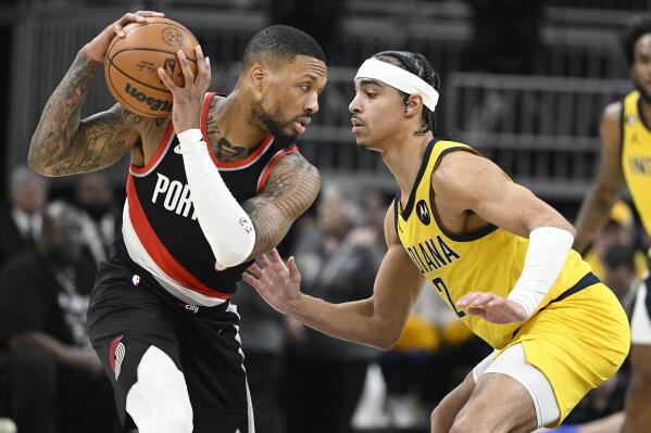Portland Trail Blazers guard Damian Lillard, left, keeps the ball away from Indiana Pacers guard Andrew Nembhard (2) during the second quarter of an NBA basketball game, Friday, Jan. 6, 2023, in Indianapolis. (AP Photo/Marc Lebryk)