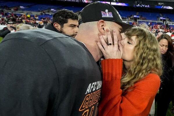 Taylor Swift kisses Kansas City Chiefs tight end Travis Kelce after an AFC Championship NFL football game against the Baltimore Ravens, Sunday, Jan. 28, 2024, in Baltimore. The Kansas City Chiefs won 17-10. (AP Photo/Julio Cortez)