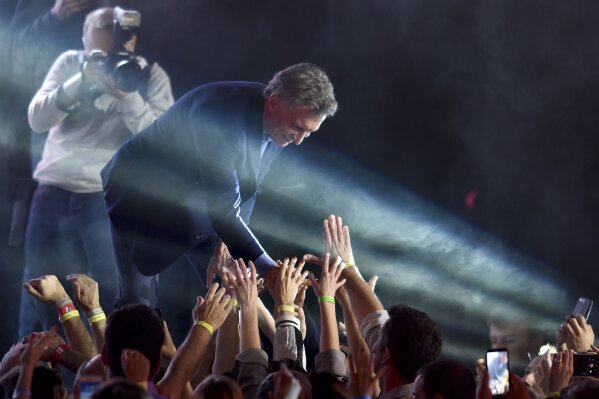 President Mauricio Macri, who was running for reelection, greets supporters after he conceded defeat in Buenos Aires, Argentina, Sunday, Oct. 27, 2019. (AP Photo/Gustavo Garello)
