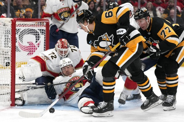 Pittsburgh Penguins' Rickard Rakell (67) gets to a rebound off Florida Panthers goalie Sergei Bobrovsky (72) and Sam Reinhart (13) during the second period of an NHL hockey game in Pittsburgh, Wednesday, Feb. 14, 2024. Rakell scored on the play but the goal was disallowed upon review. (AP Photo/Gene J. Puskar)