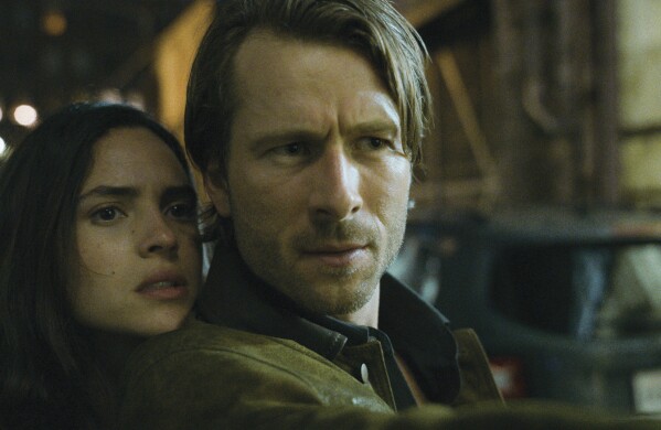 This image released by Netflix shows Adria Arjona, left, and Glen Powell in a scene from "Hit Man." (Netflix via AP)