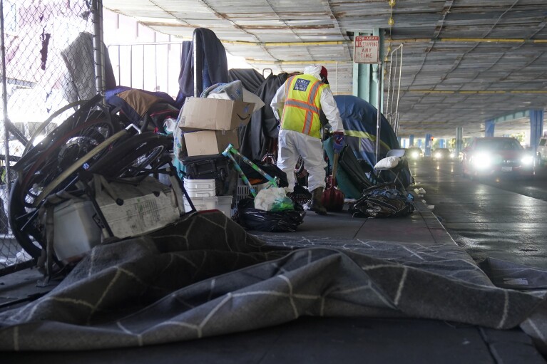 A San Francisco Public Works crew cleans items from a homeless encampment in San Francisco, Tuesday, Aug. 29, 2023. Cities across the U.S. are struggling with and cracking down on tent encampments as the number of homeless people grows, largely due to a lack of affordable housing. Homeless people and their advocates say sweeps are cruel and costly, and there aren't enough homes or beds for everyone. (AP Photo/Jeff Chiu)