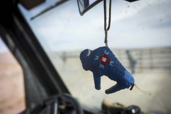 Beadwork, with the likeness of a buffalo, dangles from a rearview mirror in a vehicle used by the Wind River Tribal Buffalo Initiative during the buffalo release at the Eastern Shoshone Buffalo Enclosure on Friday, April 11, 2025, on the Wind River Reservation near Morton, Wyo. (AP Photo/Amber Baesler)