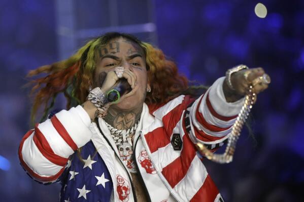 FILE- In this Sept. 21, 2018, file photo rapper Daniel Hernandez, known as Tekashi 6ix9ine, performs during the Philipp Plein women's 2019 Spring-Summer collection, unveiled during the Fashion Week in Milan, Italy.  Bodyguards for troubled rapper Tekashi 6ix9ine turned New York City into the Wild West last summer, piling into SUVs and chasing a man for 20 blocks with lights flashing after he attempted to record cellphone video of the recording star, prosecutors said Monday, July 19, 2021.  (AP Photo/Luca Bruno, File)