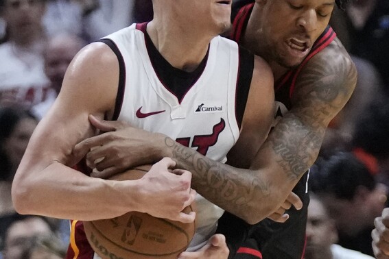 Chicago Bulls guard Dalen Terry, rear, attempts to steal the ball from Miami Heat guard Tyler Herro during the first half of an NBA basketball play-in tournament game, Friday, April 19, 2024, in Miami. (AP Photo/Wilfredo Lee)